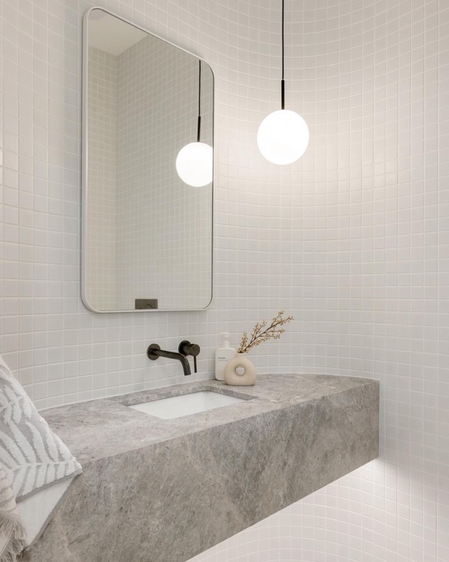 SPECTRE. On The Market. ⠀⠀⠀⠀⠀⠀⠀⠀⠀ Take a look at the finer details of the bathrooms at SPECTRE. From floor to ceiling, every inch adorned with small square tiles creating a mesmerizing mosaic. Tundra stone lending its natural elegance to the space, while sleek matte black fixtures add a touch of modern…